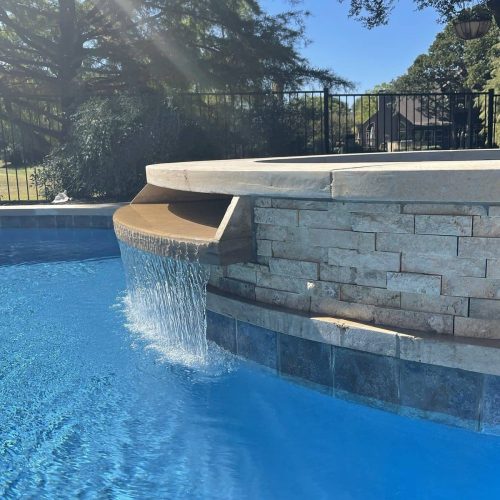 Inviting pool deck with travertine pavers in Canyon Falls 76226